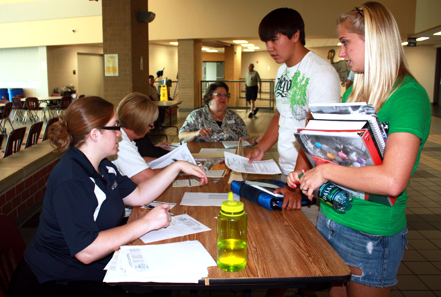 Alesha Stroh and Brad Samakim, both 12, talk to the Newman admissions representatives on Aug. 30.  Students signed up for dual-credit classes offered through the Advanced Standing program at Newman University. Photo by A. Esser