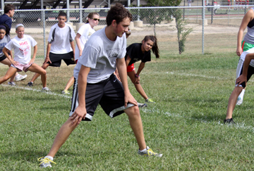 Everett Lacy, 11, does stretches to get warmed up for running on Sept. 4 at practice. Picture by C. Kasitz