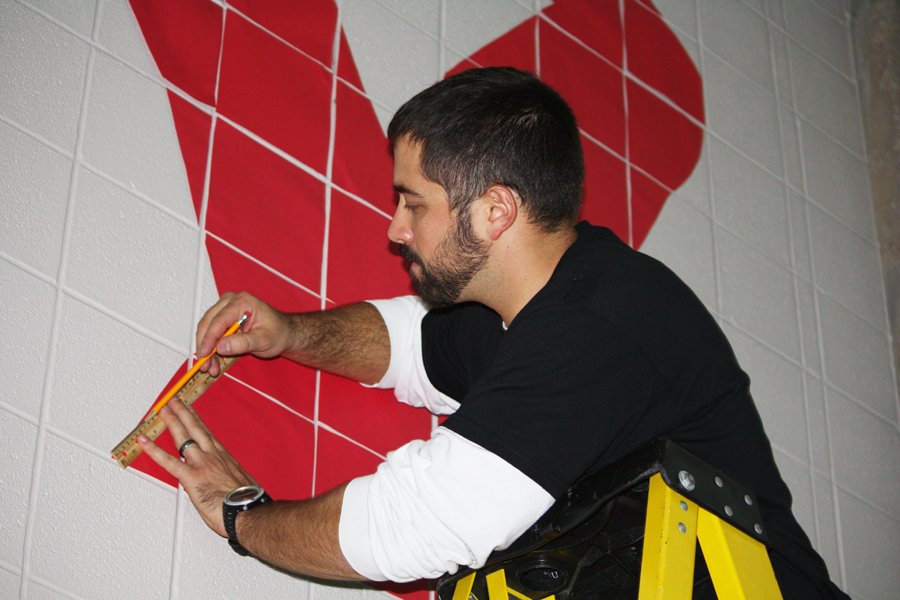 Adam Melichar, counseling, measures to make sure the ribbon is exactly as it was designed. He assisted SADD members in putting up a colossal ribbon in the commons for Red Ribbon Week awareness. Photo by T. Mitchell