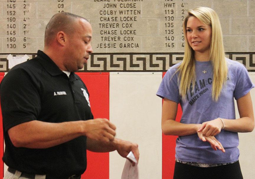 Officer Parker speaks to junior Keiryn Swenson about the correct way to execute a move in his self-defense class taught during En-cor. Photo by Maite Menendez.