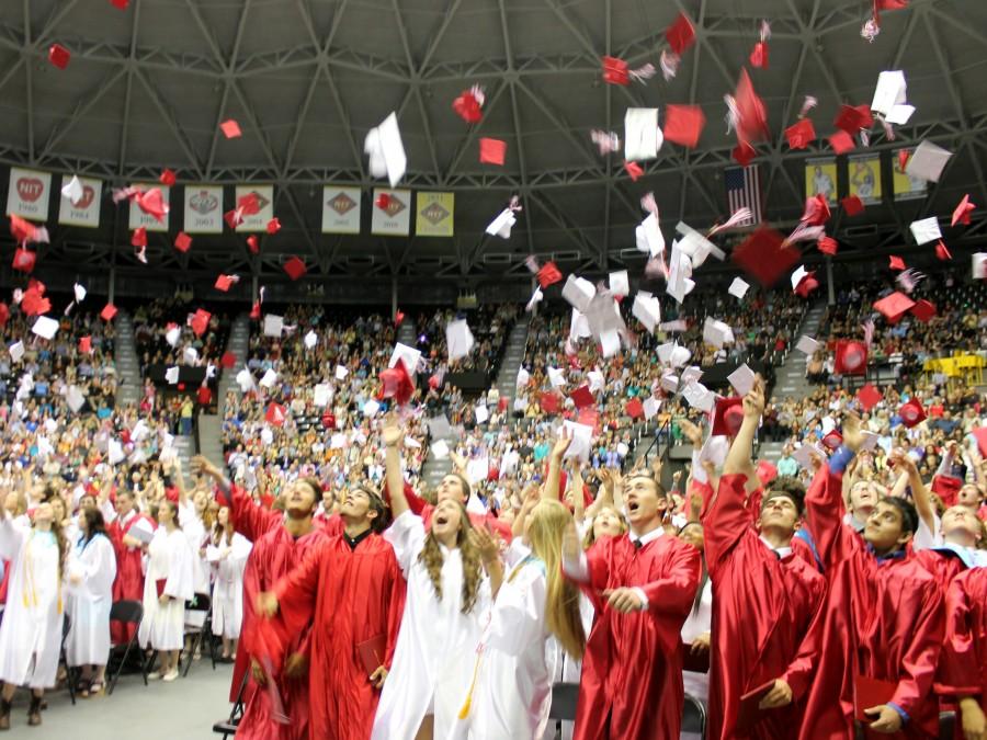 2014 graduates throw caps at the end of ceremony on May 18.
