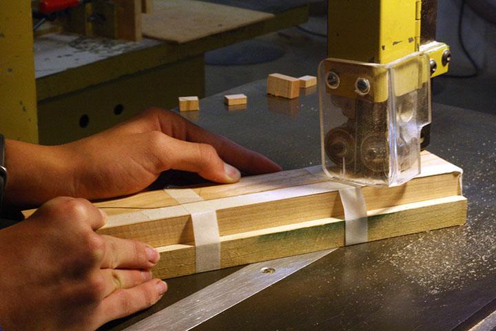 Freshman Ethan Kingrey cuts wood to create a recipe box in cabinet and furniture design. 