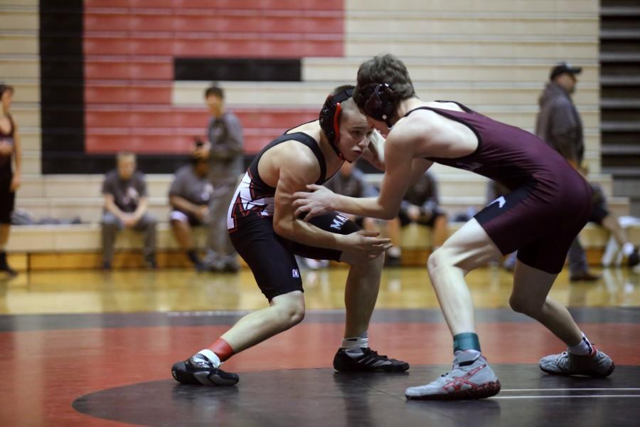Freshman Tanner Lane looks for a way to take down his opponent from Salina Central during his meet on Dec 18.