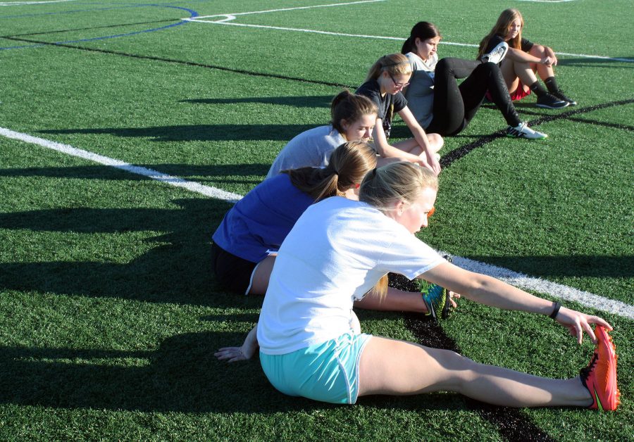 Soccer girls begin practice by stretching out. While getting to know one another. Photo by K. Angle