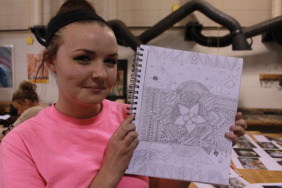 Cutline: Freshman Katelyn Catron is holding her favorite sketch she drew this year in Terry Bussart’s Art I class. Photo Illustration by Alaina Cunningham