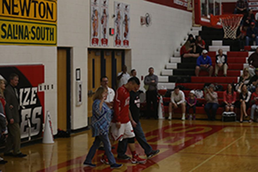 Richard Wu is escorted by his host parents on senior night.