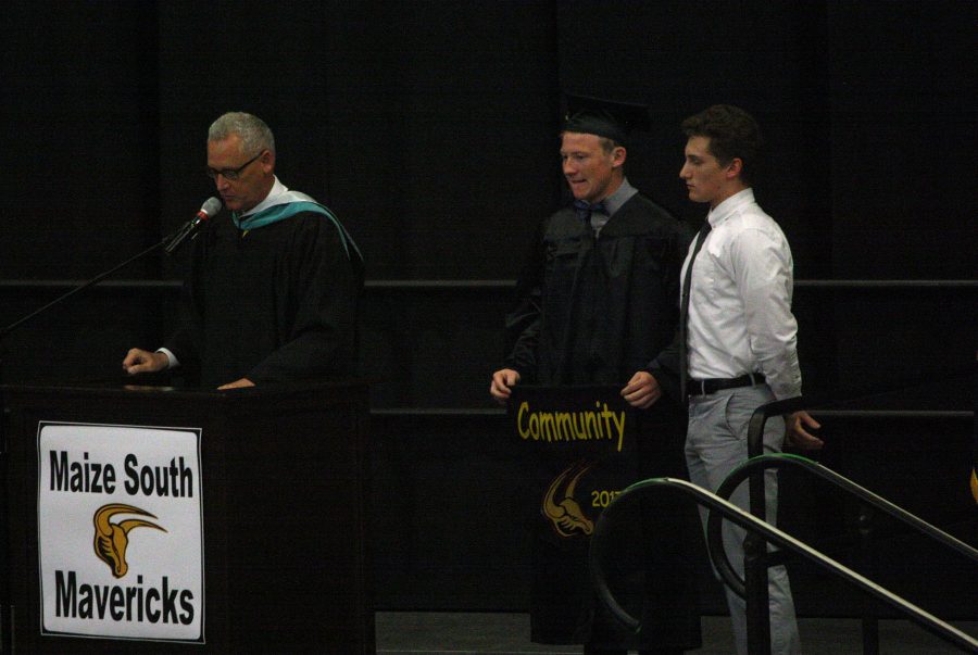 Dave Hickerson, principal, introduces T.C. Poynter, 12, to give Tanner Luce, 11, the senior banner.  Photo by K. Cabrera