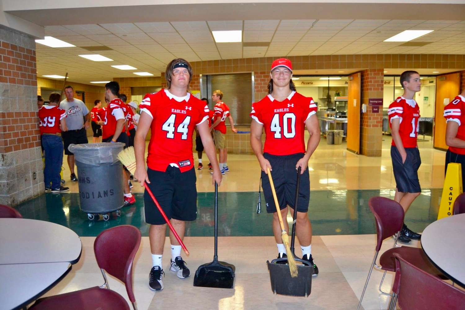Senior football players Garrison Norris (left) and Cameron Hughbanks (right) helped keep the Commons clean during the feed last year. The football players all participate in the feed. 