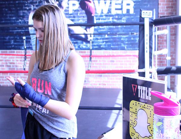 Courtney Walter, 11, prepares to box by wrapping her wrists. The wrap was provided by Title Boxing. Photo by A. Zwetzig