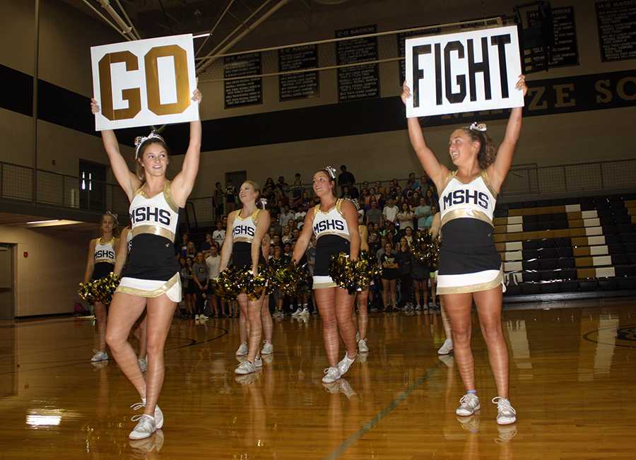 Salone Gleeson, 12, and Mackenzie Farney, 11, hold up signs to go along with their cheer. The cheer squad hyped up the crowd during the pep assembly on Sept. 8. Photo by B. Jones-Rupp