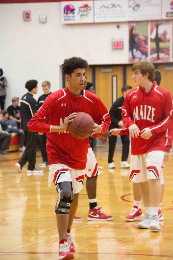 Junior Cade McGaugh warms up with his team before the game against Newton. 