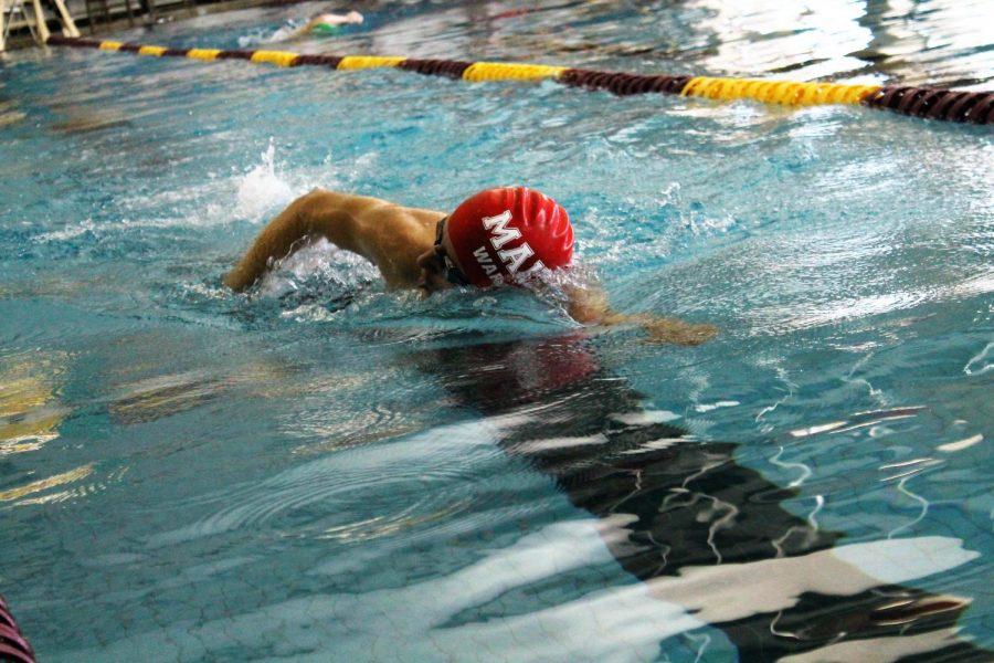 Senior Peyton Wardell competes in the 500 yard freestyle. Many of his teammates were cheering him on at the side of the pool. 