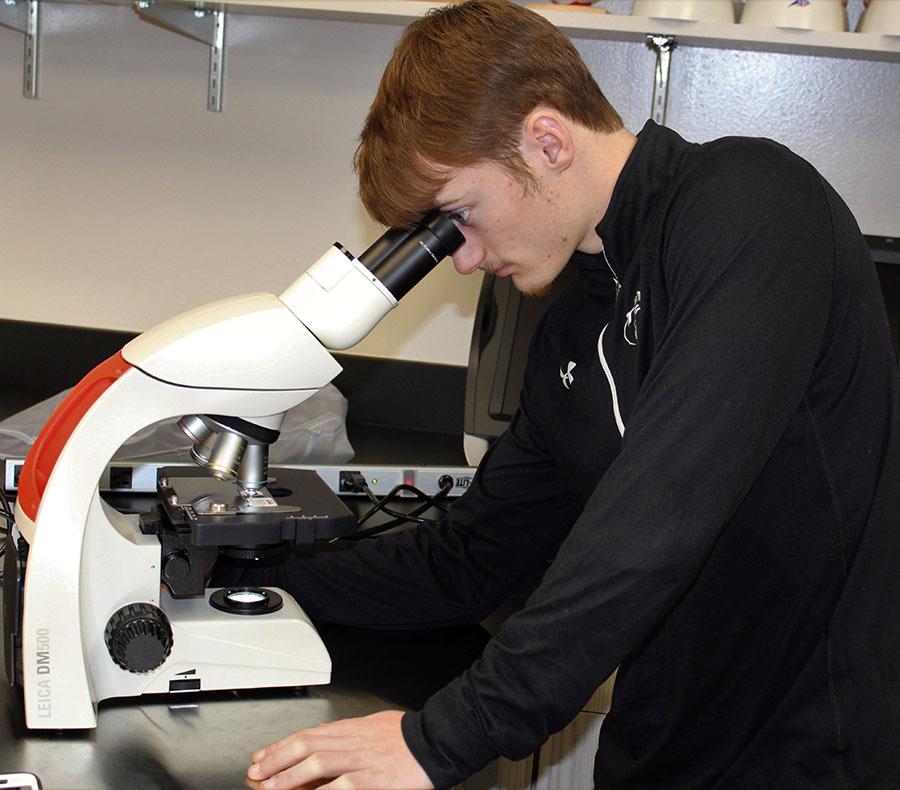 South student, Andrew Bliss, 11, looking into a microscope. The microscope is a new piece of equipment available to students at the Maize Career Academy. Photo by A. Wilks