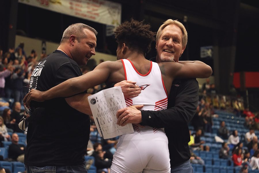Sophomore Duwayne Villalpando celebrates with coaches Mike Schauer and Bryce Hughbanks after placing first at the state wrestling meet on Saturday. Villalpando won his first league title as a sophomore.