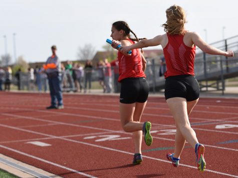 Sophomore Aria Sheldon hands off the baton to senior Tania Allen. The track team competed at the KU Relays on Saturday. 
