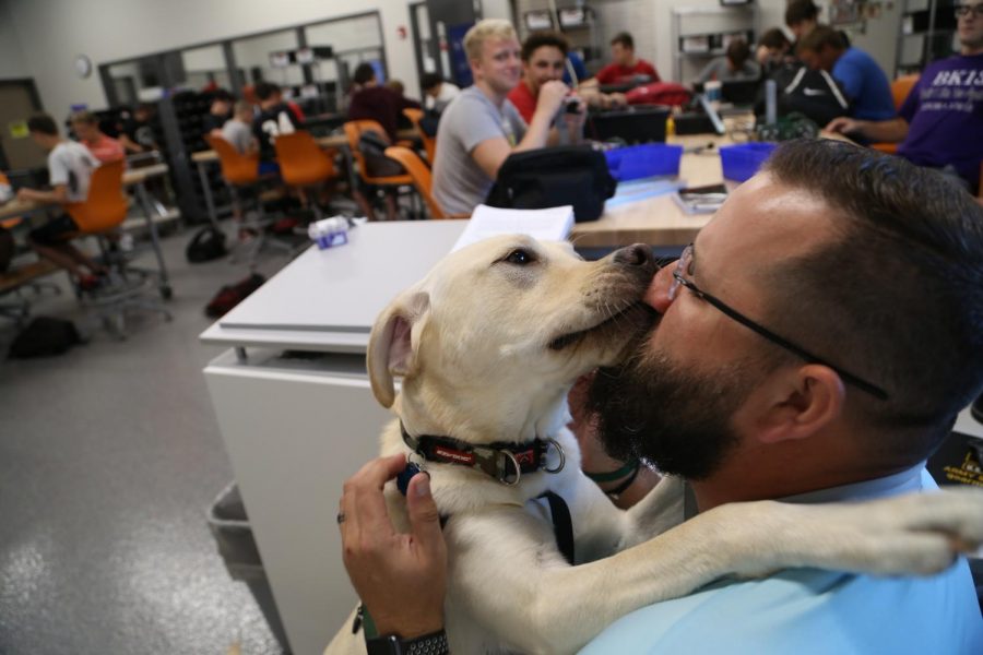 Major gives kisses to handler Jed Heath during robotics. Major is allowed to roam around the class and provide comfort to distressed students. Photo by Sam Bartlett