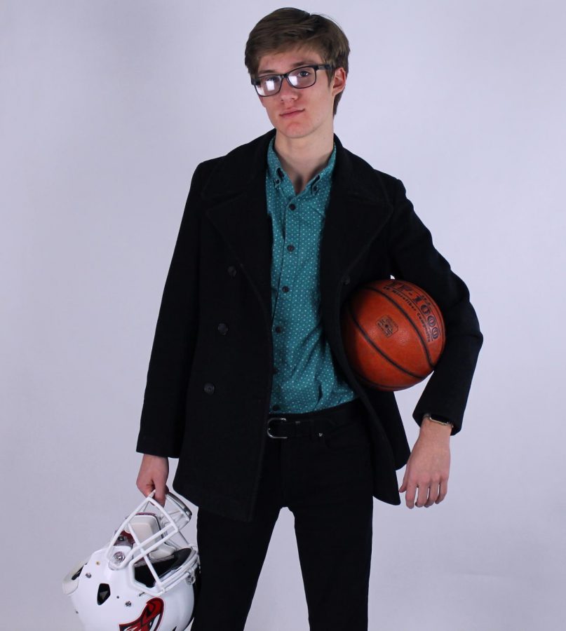 Carter Jones posing with basketball and football helmet. 