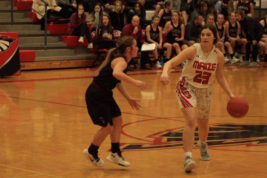 Emily Laham dribbles down the court past a Buhler player.