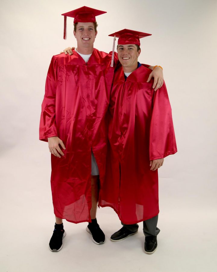 Seniors Jordon Helm and Deriq Doty pose in their cap and gowns.