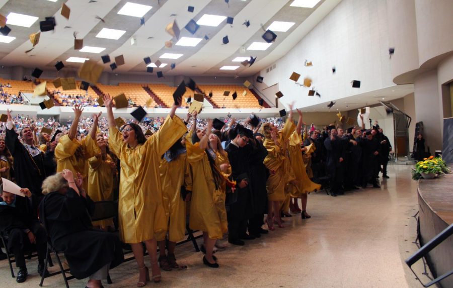 Maize South graduates of 2018 throw their caps into the air in celebration.
