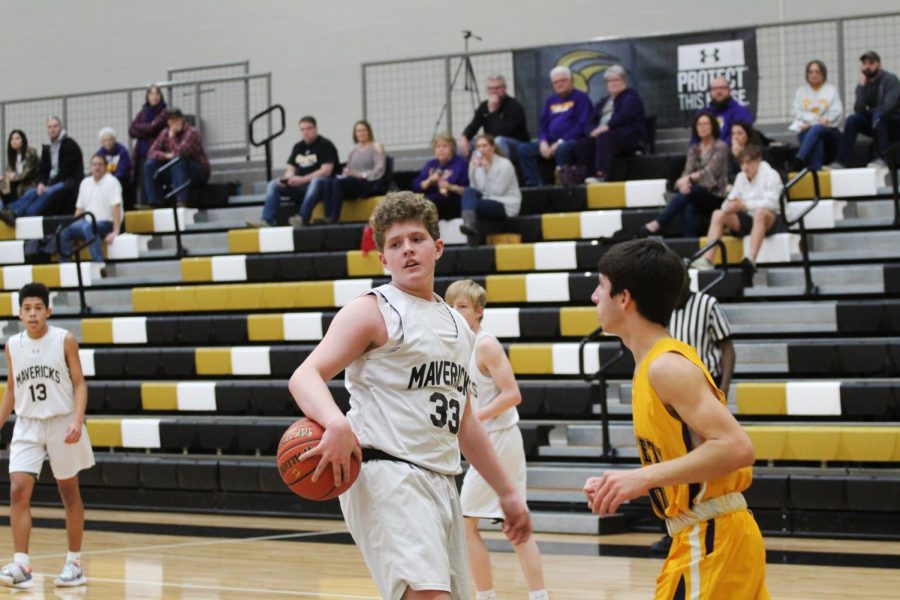 Setting the ball down after a made shot, freshman Brady Ingram looks towards his bench in the 4th quarter against the Valley Center Hornets.