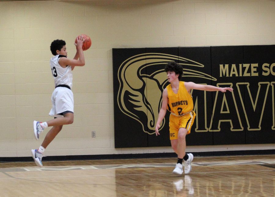 Freshman Ethan Turner attempts to pass the ball in mid-air to one of his teammates during the second half of the freshman game against Valley Center.