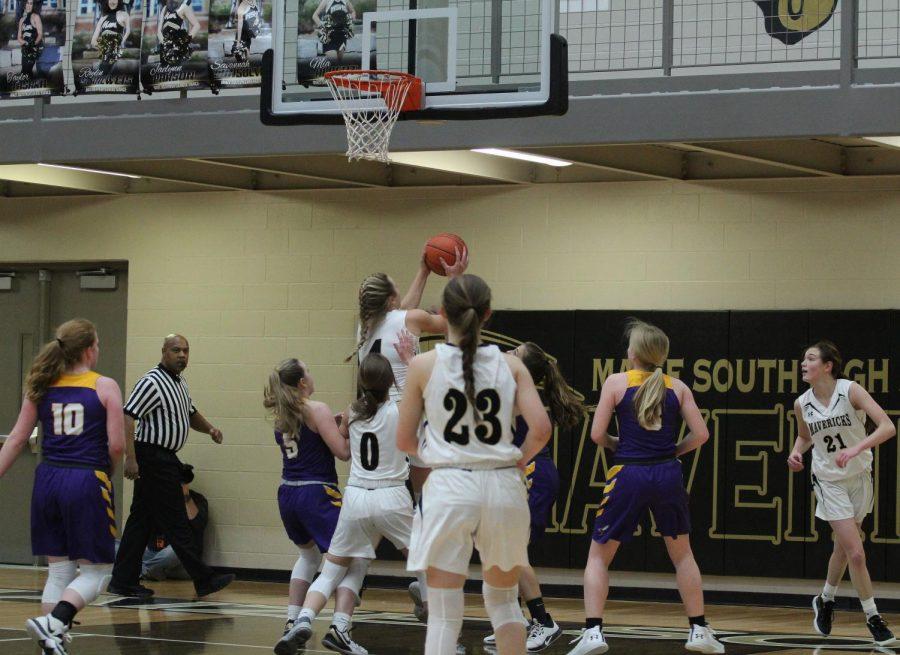 Jumping in the air to convert a layup, senior and All-Metro player Katie Wagner evades defenders for a two-point score. 