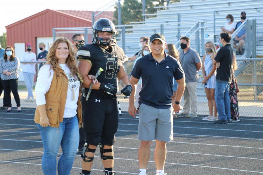 Offensive+lineman+and+starter+Alex+Bonilla+takes+a+moment+prior+to+kickoff+to+celebrate+Senior+Night+with+his+parents.+The+Mavericks+have+over+25+seniors+on+their++2020-2021+team.