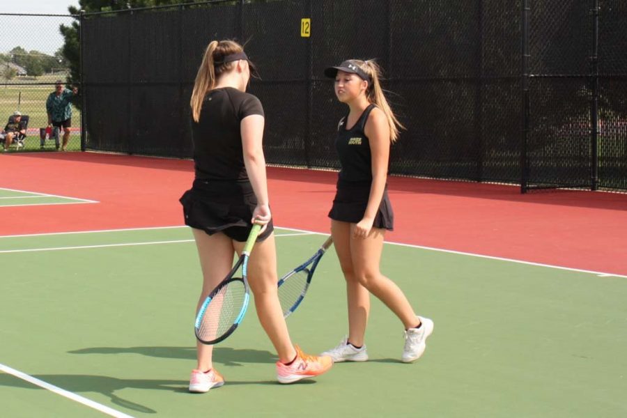 Deciding their strategy, double players Brooke Bradford (12) and Madeline Hazlewood (12) discuss their game plan during a water break. 3 of the 4 doubles partners for Maize South are senior pairs.