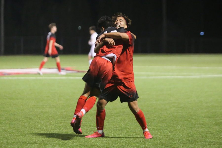After scoring a goal in the first half, sophomore Angel DeLeon hugs junior Andy Nam. The Eagles beat Great Bend 3-0 and will play Andover Central tomorrow at 4:00 p.m.