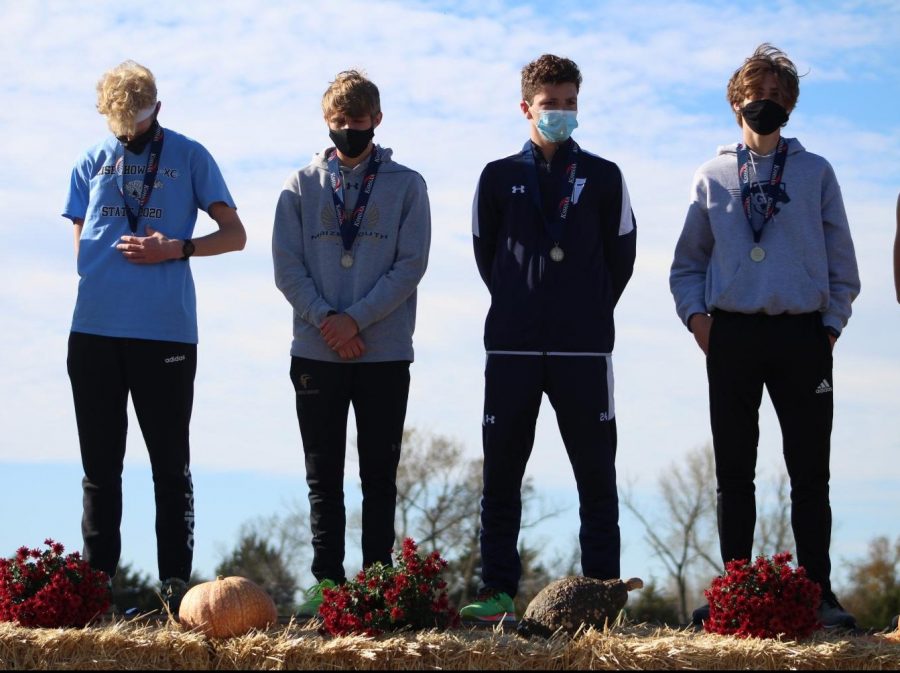 After placing in the top 20, William Schaeffer (11), stands on stage with his competitors.  Schaffer was the only runner on the boys team to place in the top twenty and helped earn the boys cross country team a sixth place finish with 160 total points.