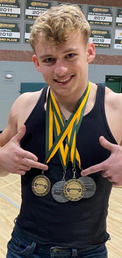 Senior Garrett Huff shows off his state powerlifting medals.  Huff took the champion 