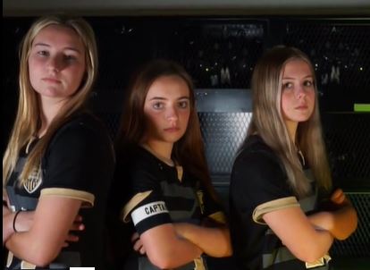 Seniors Alexa Meyer, Maddie Bliss and Jacie Doyle pose for a team video shoot in the Maize South locker room on Wednesday, March 31.