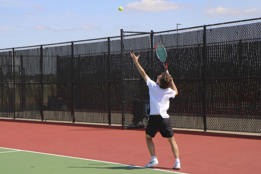 Junior Harris Kossover prepares to serve the ball against his opponent school, Campus. Kossover lost only one game in the match while winning 11, pushing Maize South even closer to their first place win.