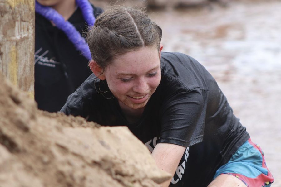 Rylee Frye (8) climbs out of one of the many mud pits as she runs through Bull Rush with her friends and classmates. Bull Rush consisted of many obstacles and mud pits runners had to wade through.