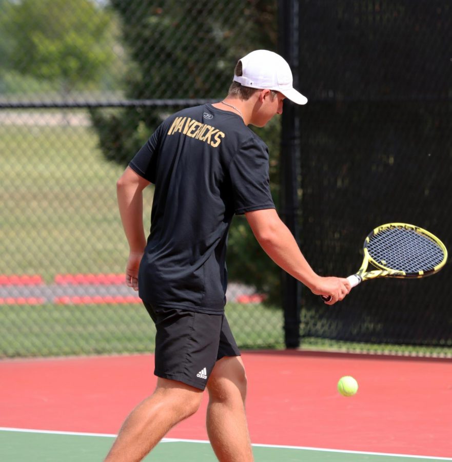 Garrison Wright (12) walks back toward the baseline with a ball to serve against his opponents from Maize High. The duo won their match and the following two matches, moving on to the final bracket against Salina Central, who will eventually won the 5A doubles tournament overall.