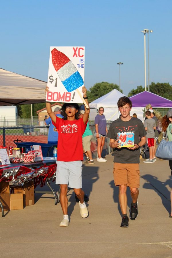 Seniors Hiep Nguyen and Aiden Werner promote $1 bomb pops to raise money for the cross country team. The fall extravaganza showcases fall sports and raises money for the teams.