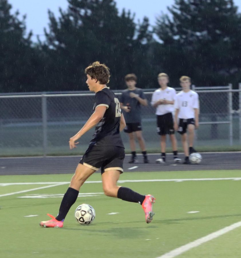 While it starts to rain on the stadium Oliver Jaberg, 12,  about to pass the ball to a teammate and attempt at a goal with the score being 5-0 in the first quarter against Salina South. 
