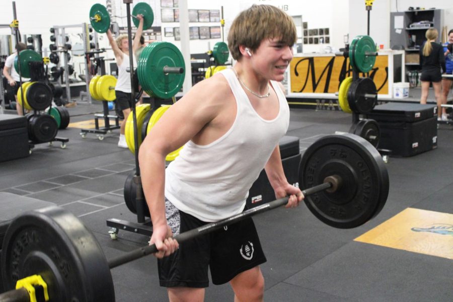 Sophomore Jaxon Sullivan performs barbell curls while looking in the mirror to get in the zone.