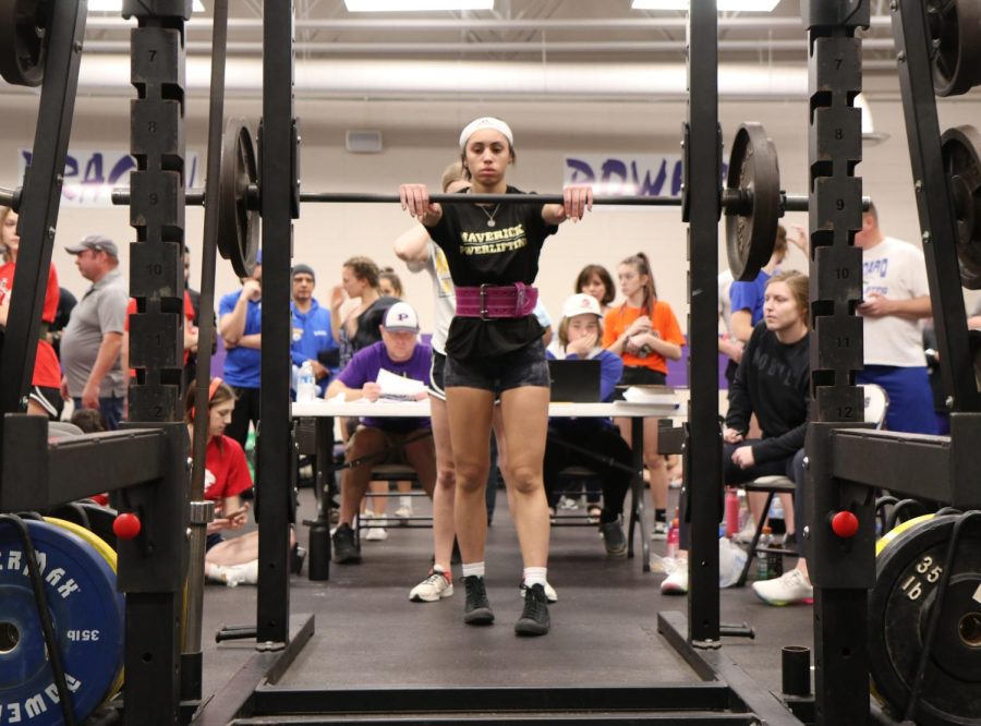 Sophomore Lily Mitchell, the only female competitor for Maize South, prepares to squat 185 pounds. Mitchell finished the meet in second place for her divison.