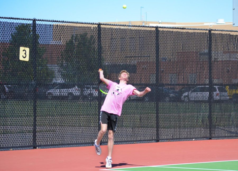Senior (name) jumps up to hit serve to his opponent.