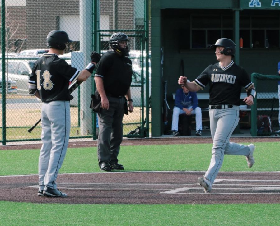 Scoring another point, Senior Owen Bailey runs to his teammates for a fist bump after making another run.