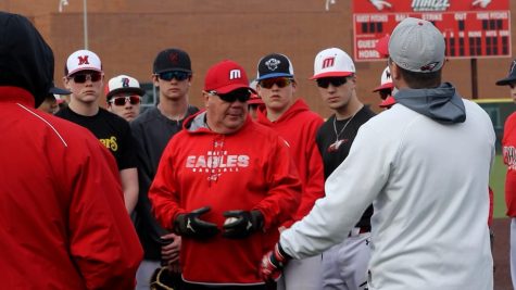 Coach Rocky Helm explains a drill to his varsity players on Tuesday, March 8. The team practiced on an icy field after a snow storm on hitting and defensive drills.