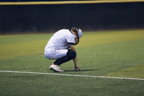 After the team huddle, senior Marshall Gilstrap takes time by himself to gather himself in the final moments of his senior baseball season.