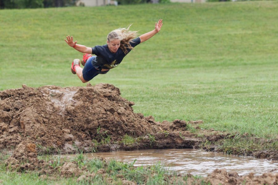 Kiley Thornquist belly flops into one of the mud pits, after being cheered on by her classmates. 