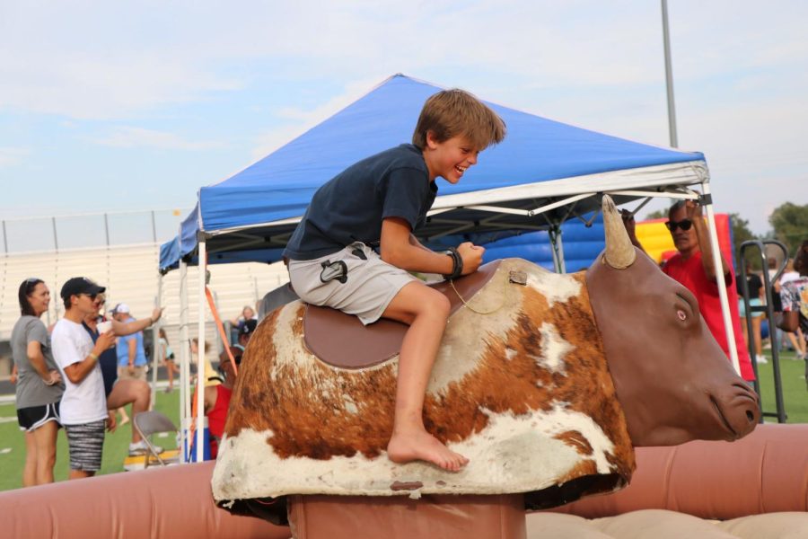A Maize South student rides the mechanical bull to try his hand at staying on the saddle.