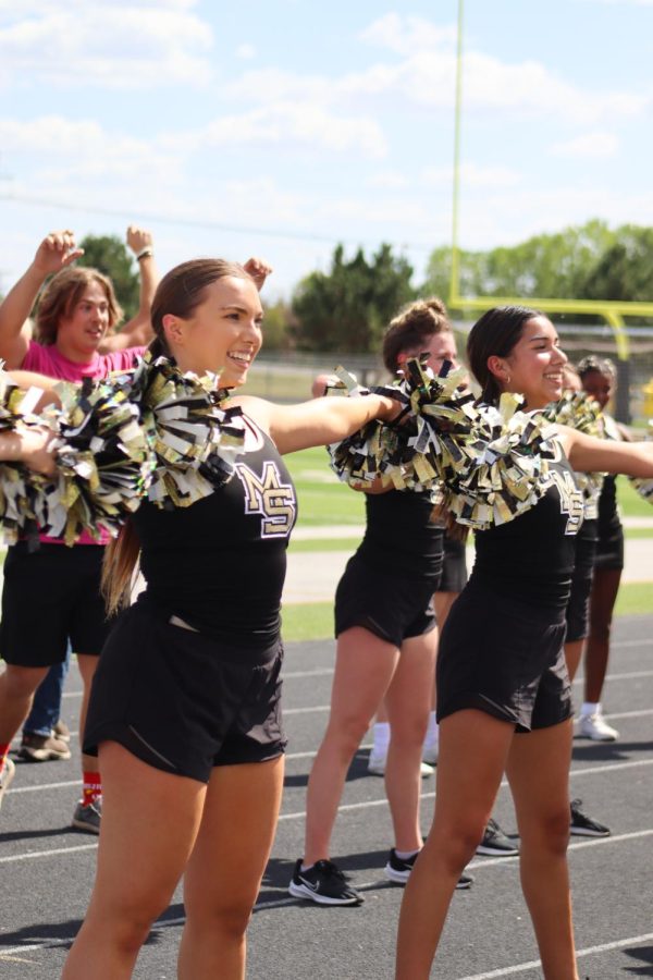 Senior Hannah Sinko along with the other members of the Maize South dance team performing for the Maverick highschool students at the Homecoming pep assembly. 
