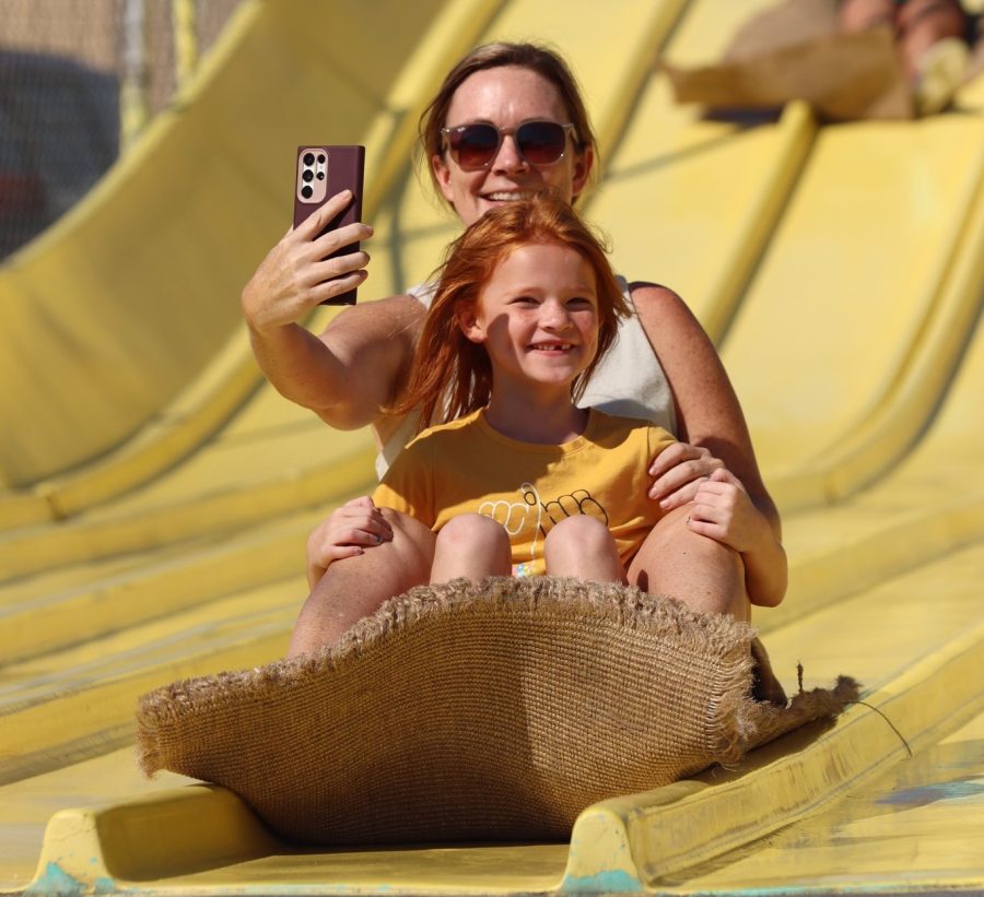 A mother rides down the large, two-person slide with her daughter taking a selfie at the Kansas State Fair on Friday, September 16.