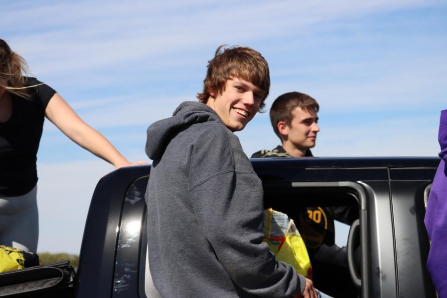 Riding in a truck that represents the bowling team, senior Jackson Graham throws candy to the students of Pray-Woodman. “Watching all the kids smile when we threw the candy was my favorite part,” said Graham. 