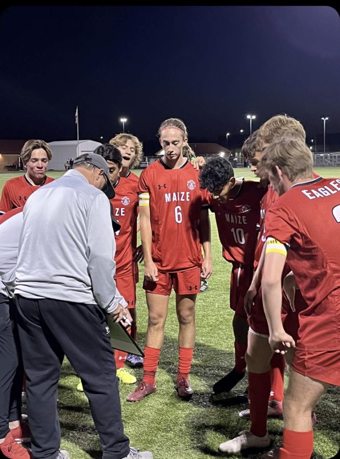 Topher+Cannizzo+and+the+varsity+team+listen+to+Coach+Jay+during+the+game+against+Northwest+at+Maize+High+School.+The+Eagles+won+with+their+third+goal+in+the+second+half%2C+3-2.